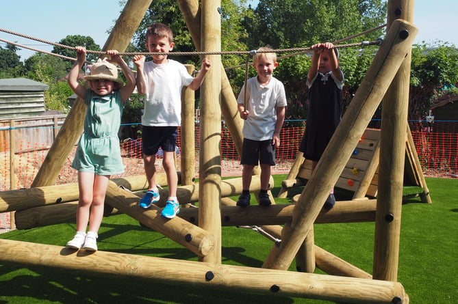 New climbing frames in the Year R playground at The Holme CE Primary School in Headley, being tried out by pupils Matilda, William, Max and Ava during the opening ceremony on July 19th 2022.