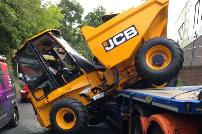 A JCB was knocked off the back of a trailer into incoming traffic after a collision with the A325 Wrecclesham Road railway bridge on Tuesday