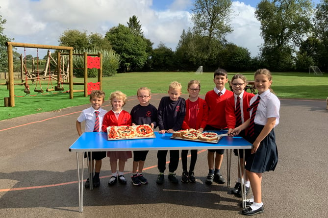 Pupils at St Mary’s Bentworth CE Primary School with two ‘150’ cakes to celebrate 150 years of it being a church school, September 2022.