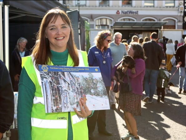 Lions president Mandy Main holding a calendar at the food festival