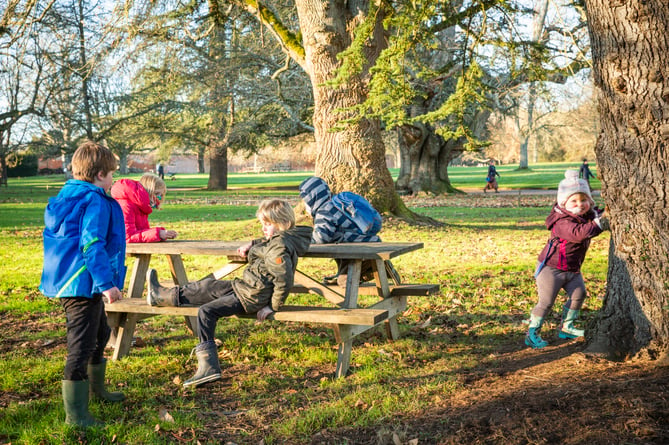 Children playing on a picnic bench at Mottisfont