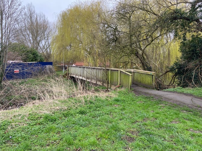 The wooden footbridge across the River Wey by the 40 Degreez youth centre, which councillor Andy MacLeod acknowledged is in a 'shocking condition'