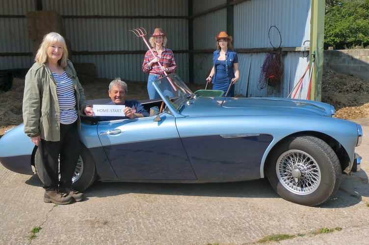 Bill Rawles gives a sponsorship cheque to Sally Stewart of Home-Start Winchester watched by Suzanne and Charlotte Rogers, June 2023.