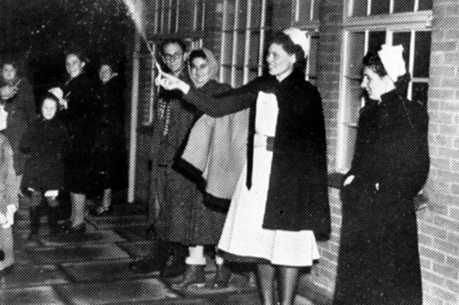 A nurse holds a small firework to celebrate 1949’s Guy Fawkes Night at Trimmer’s Hospital in Farnham