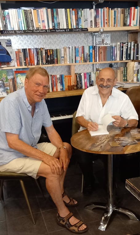 Author John Jacobs, right, signs his book Travels With High Frequency for Gordon Jones, Goldfinch Books, High Street, Alton, September 6th 2023.