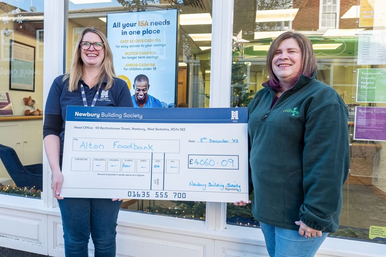 Julie Harness of Newbury Building Society, left, gives a cheque to Sian Mills of Alton Foodbank at Newbury Building Society, Alton, December 2023.