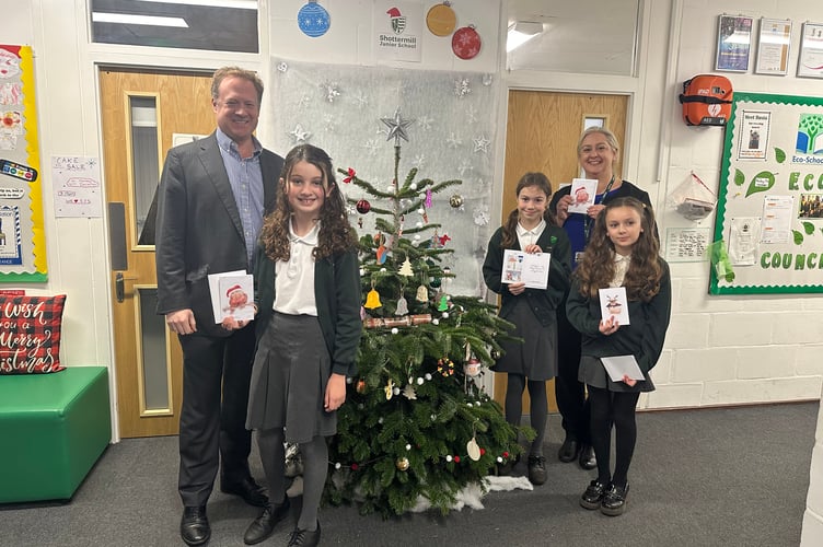 Left to right: MP Greg Stafford, winner of Christmas card competition Evelyn, runners up Ruby and Pinelopi, and Shottermill headteacher Kate Burns