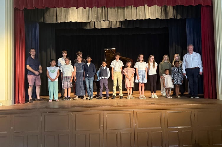 Young pianists on stage at the end of the Grayshott Children's Piano Concert at Grayshott Village Hall on June 22. East Hampshire district councillor Tom Hanrahan is far left and Mark Stephenson is far right.