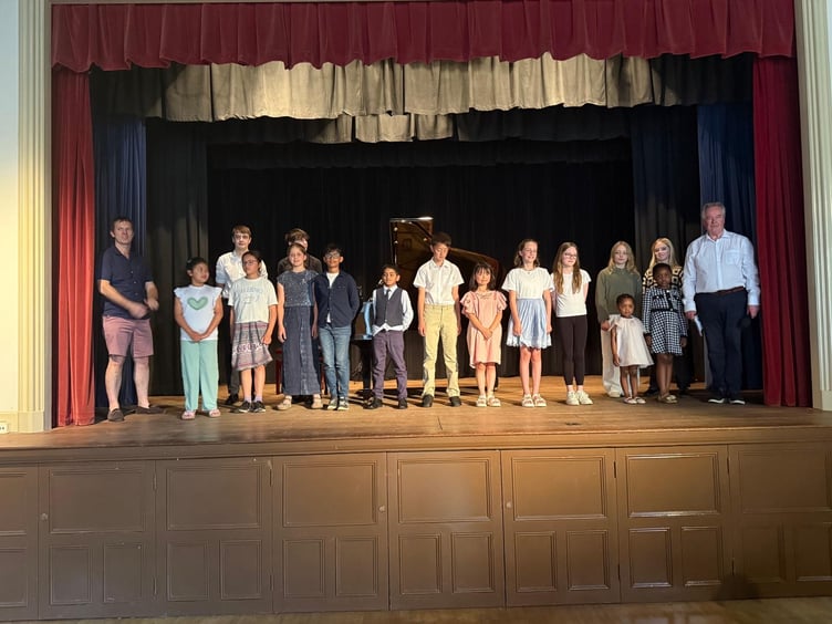 Young pianists on stage at the end of the Grayshott Children's Piano Concert at Grayshott Village Hall on June 22. East Hampshire district councillor Tom Hanrahan is far left and Mark Stephenson is far right.