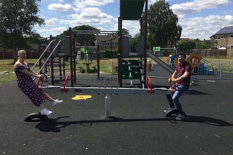Cllr Andy Tree, EHDC deputy leader and portfolio holder for the Whitehill and Bordon Area, and Cllr Catherine Clark, ward councillor, try out the new play equipment at Hollybrook Recreation Park.
