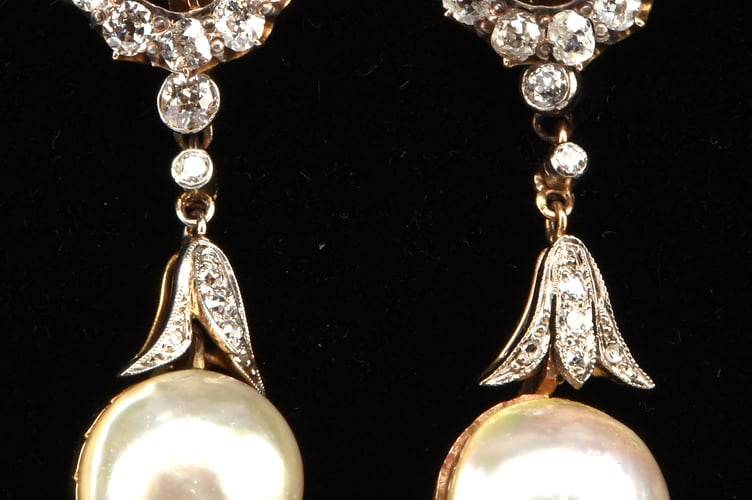 A pair of day and night diamond and drop pearl earrings.